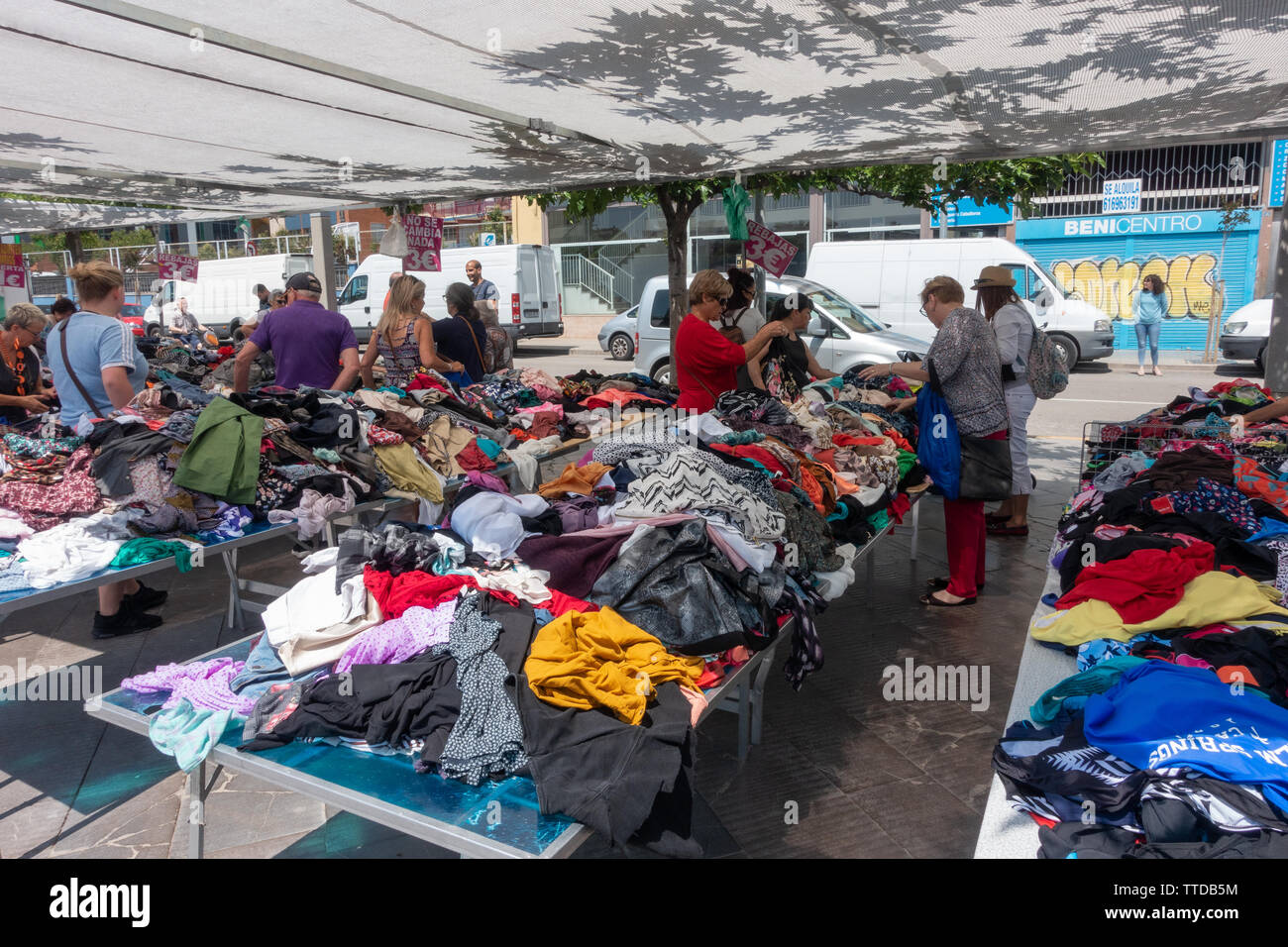 Des piles de vêtements pour revue dans une vente à un marché local vêtements espagnol Banque D'Images