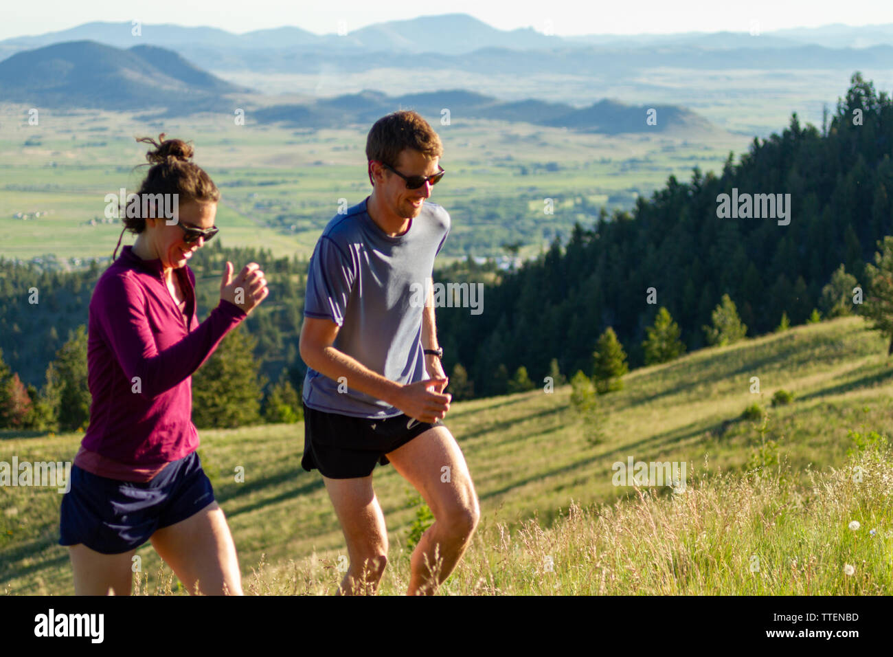 Un couple millénaire exécutant hills ensemble au début de la lumière du matin. Une partie de leur propre, actif, mettre en place, et d'un style de vie sain. Le Montana, USA. Banque D'Images