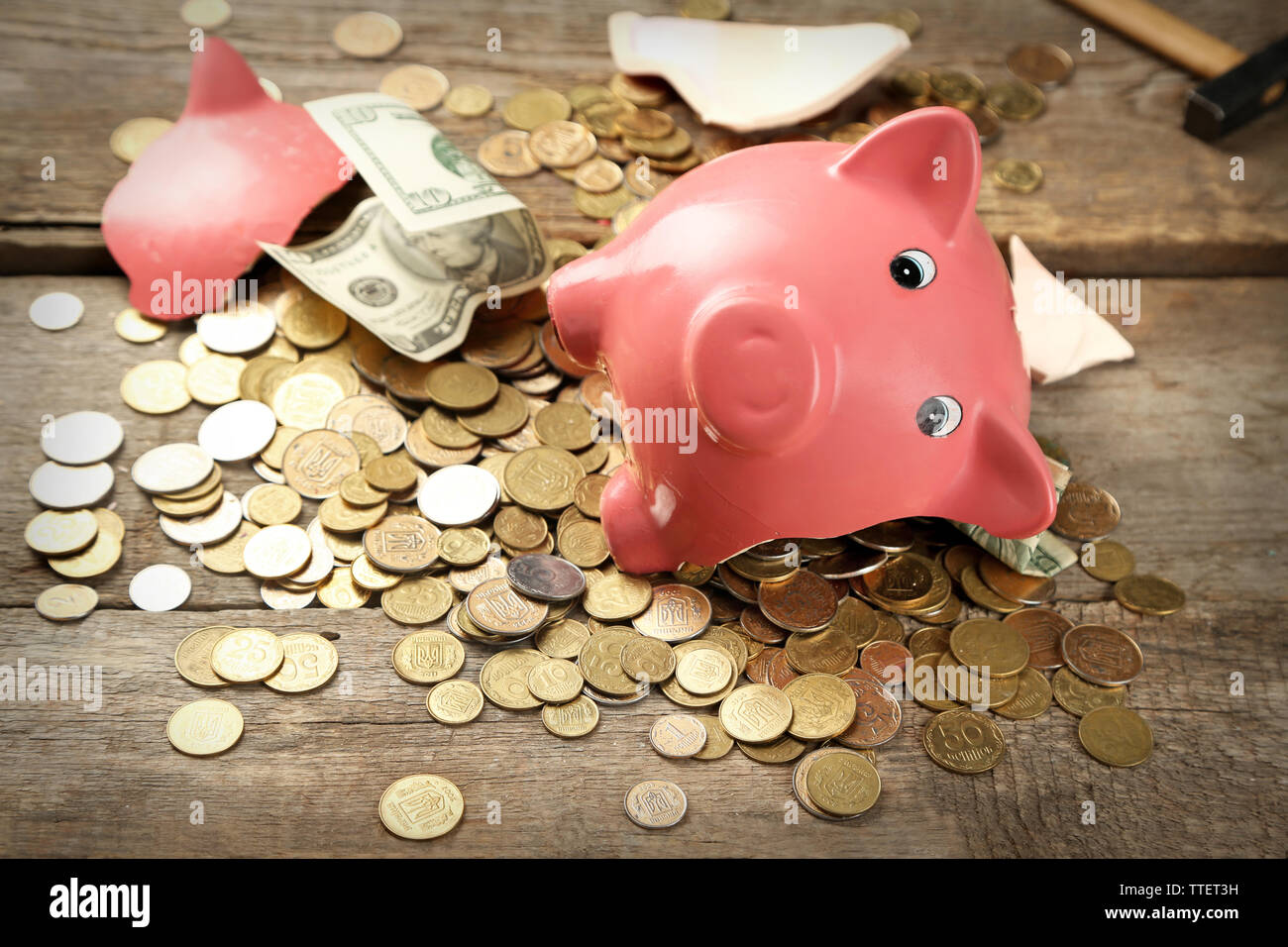 Tirelire cassée avec de l'argent et des pièces sur fond de bois Photo Stock  - Alamy