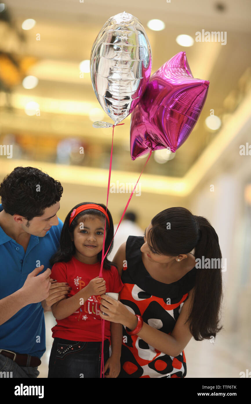 Fille avec ses parents dans un centre commercial Banque D'Images