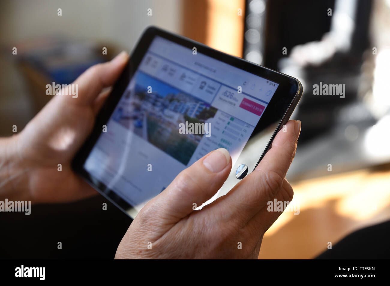 Close up of a senior woman holding an Apple iPad mini maison de l'accès à l'information en ligne. Banque D'Images