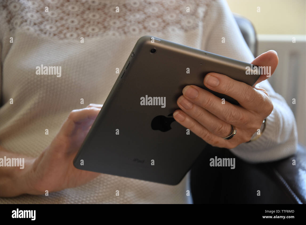 Close up of a senior woman holding an Apple iPad mini. Banque D'Images