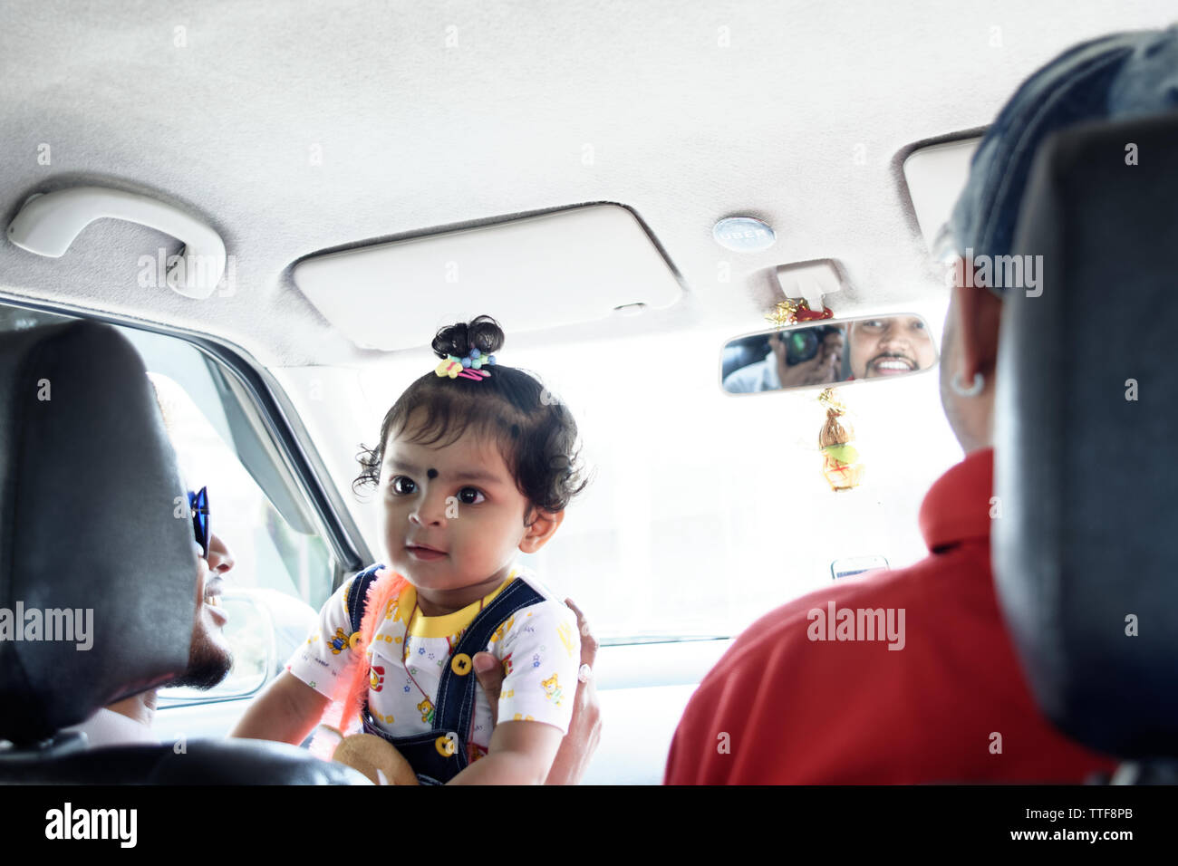 Une belle petite fille indienne enfant équitation dans une voiture Banque D'Images