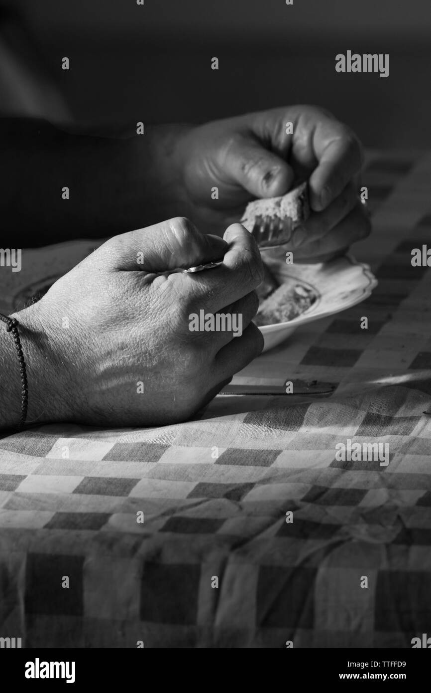 Mains d'un seul homme qui mange à midi, photo en noir et blanc Banque D'Images