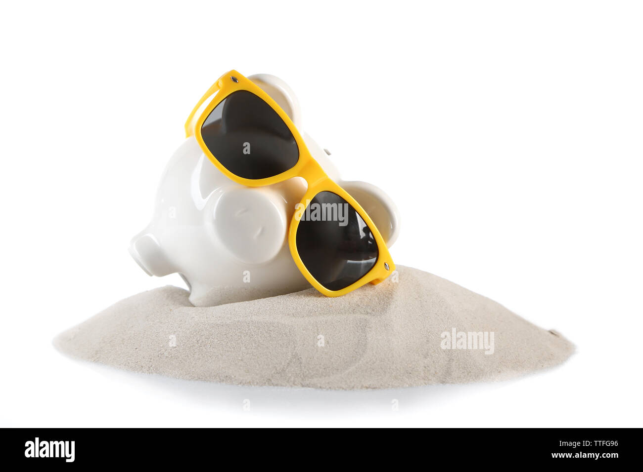 Tirelire avec des lunettes de soleil sur un sable, isolé sur blanc. Maison de vacances money concept Banque D'Images