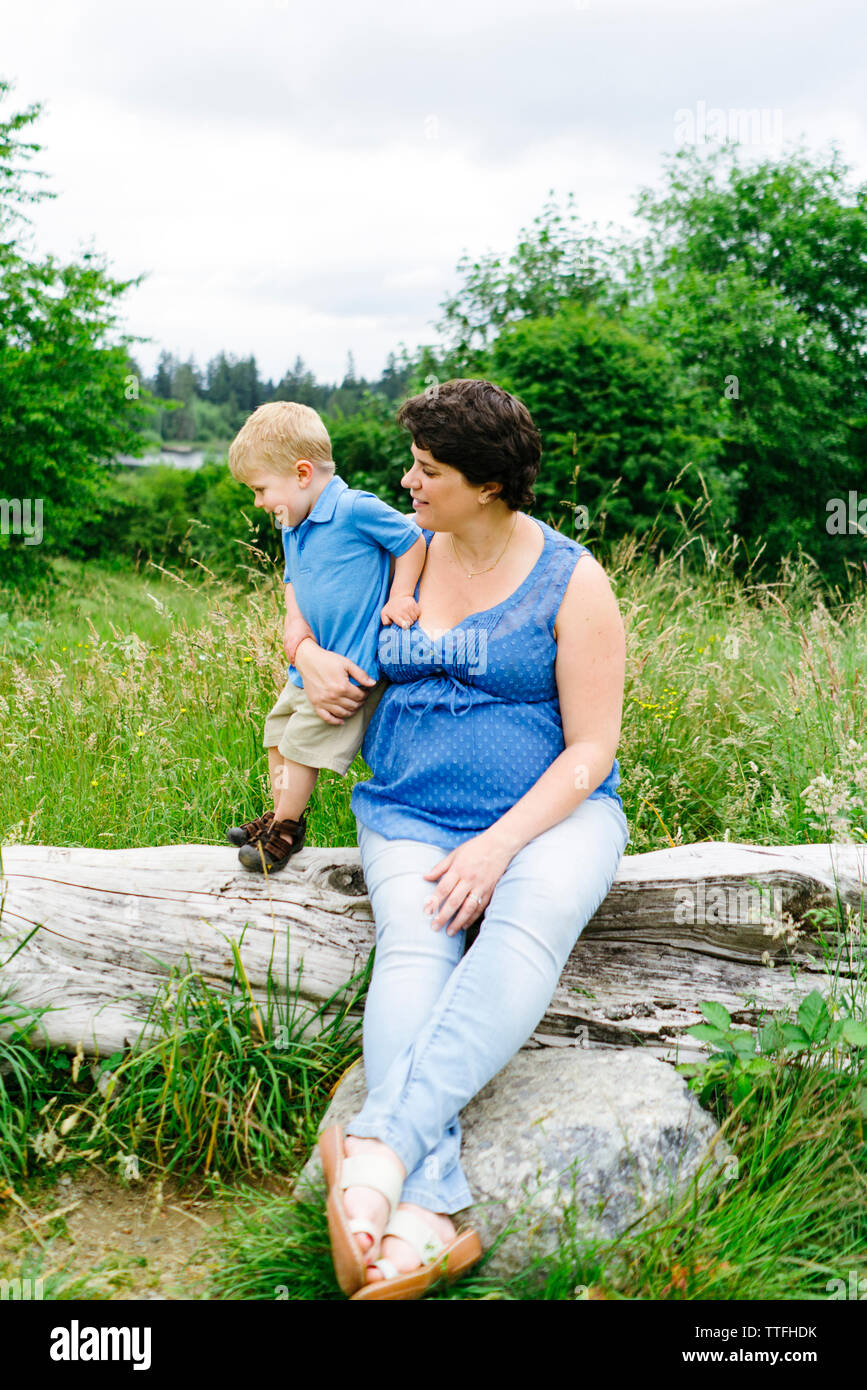 Tout droit sur portrait d'une maman et son fils assis sur un journal de grève Banque D'Images