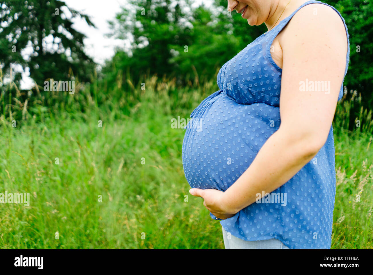 Vue latérale d'une mère enceinte en regardant son ventre Banque D'Images