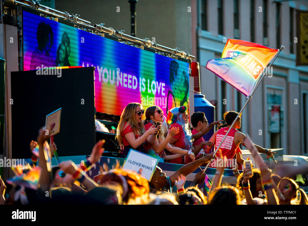 NEW YORK - 25 juin 2017 : les participants sur un flotteur parrainé par la marque de vodka Smirnoff vague gay pride rainbow flags lors de l'Assemblée Pride Parade. Banque D'Images