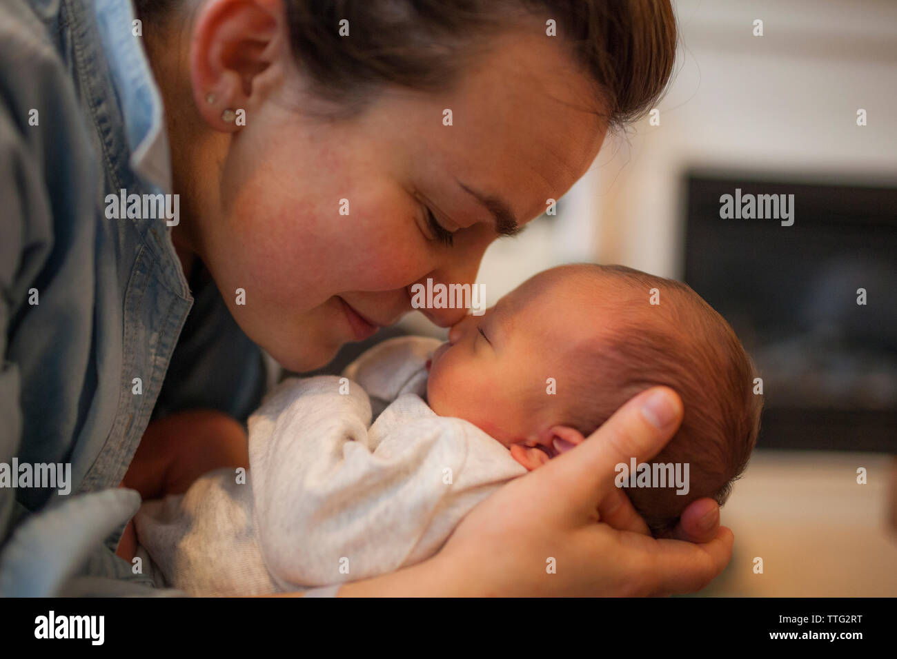 Mère rubbing noses avec bébé garçon à la maison Banque D'Images