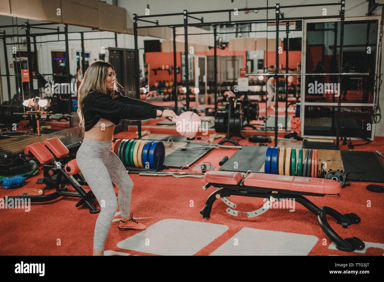 Fit woman l'entraînement avec kettlebell rose dans la salle de sport Banque D'Images