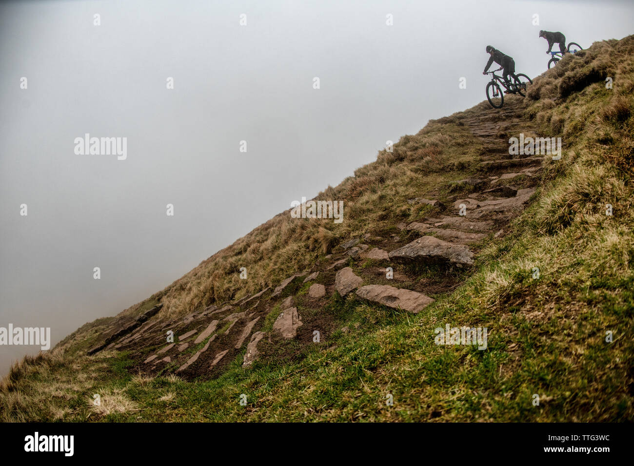 Un homme et une femme ride vtt sur une piste escarpée près de fan-y-grand dans le parc national de Brecon Beacons, le Pays de Galles. Le vélo de montagne. Banque D'Images