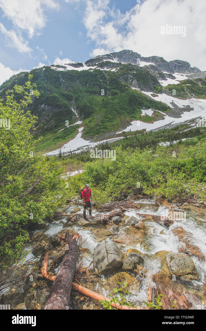 Hiker crossing River en route vers le pic de cyprès, C.-B. Banque D'Images