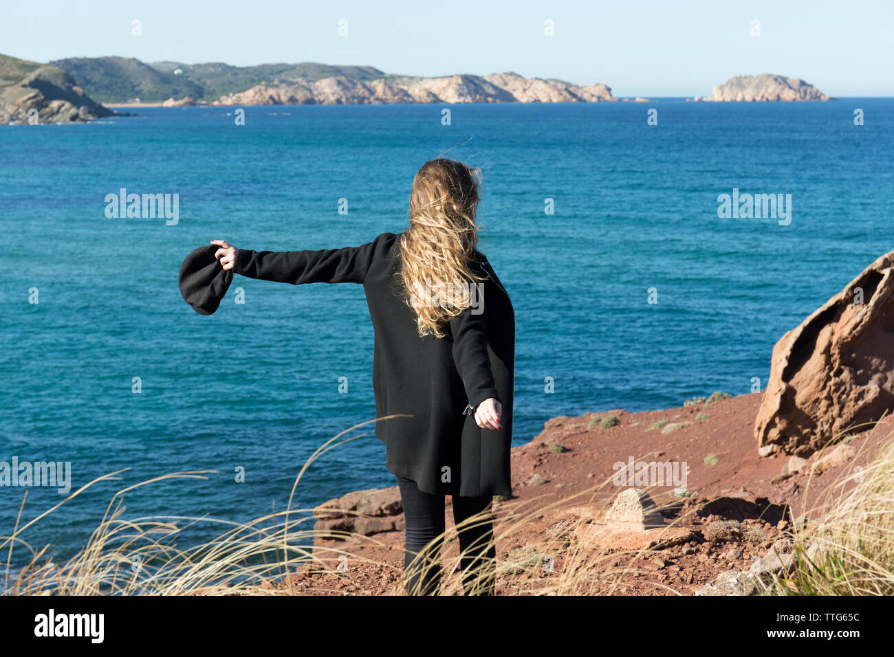 Young woman looking at view en se tenant sur le rivage Banque D'Images