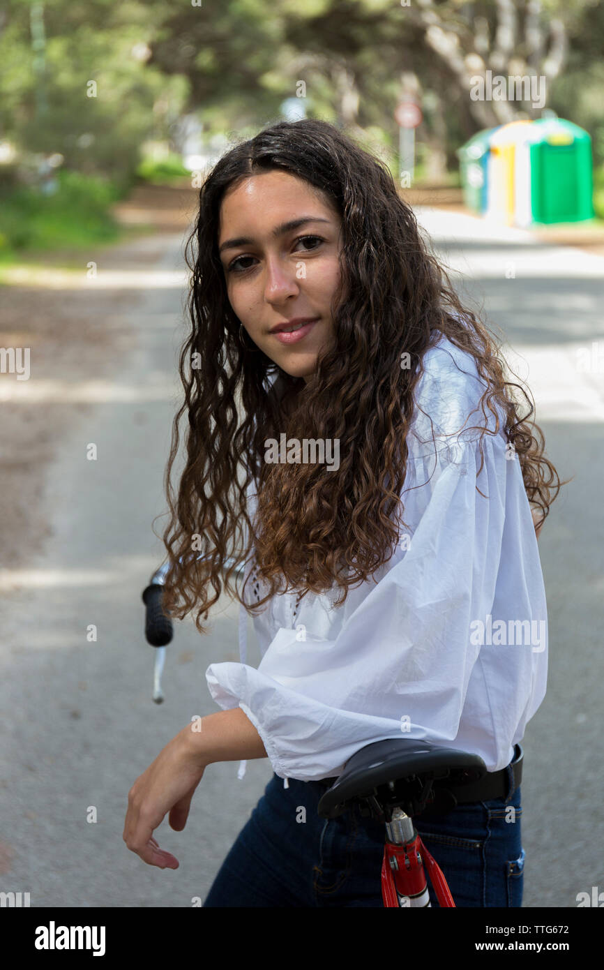 Portrait de femme avec vélo sur route Banque D'Images