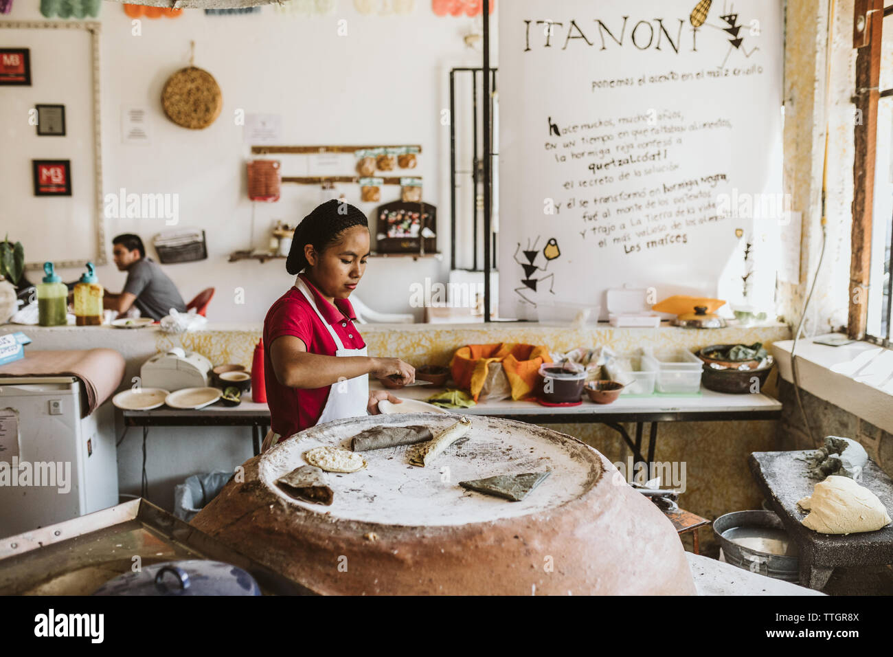 Jeune femme mexicaine quesadillas de cuisson sur four en argile traditionnel Banque D'Images