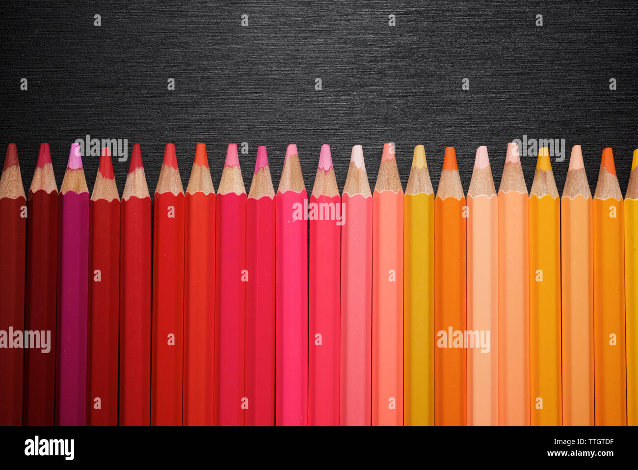 Crayons alignés sur un tableau noir. Banque D'Images