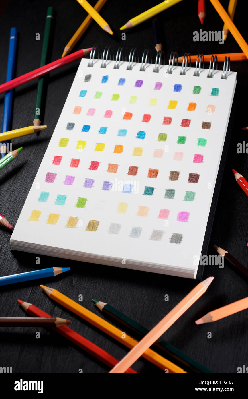 Palette de couleurs dans un carnet et crayons de couleur. Banque D'Images