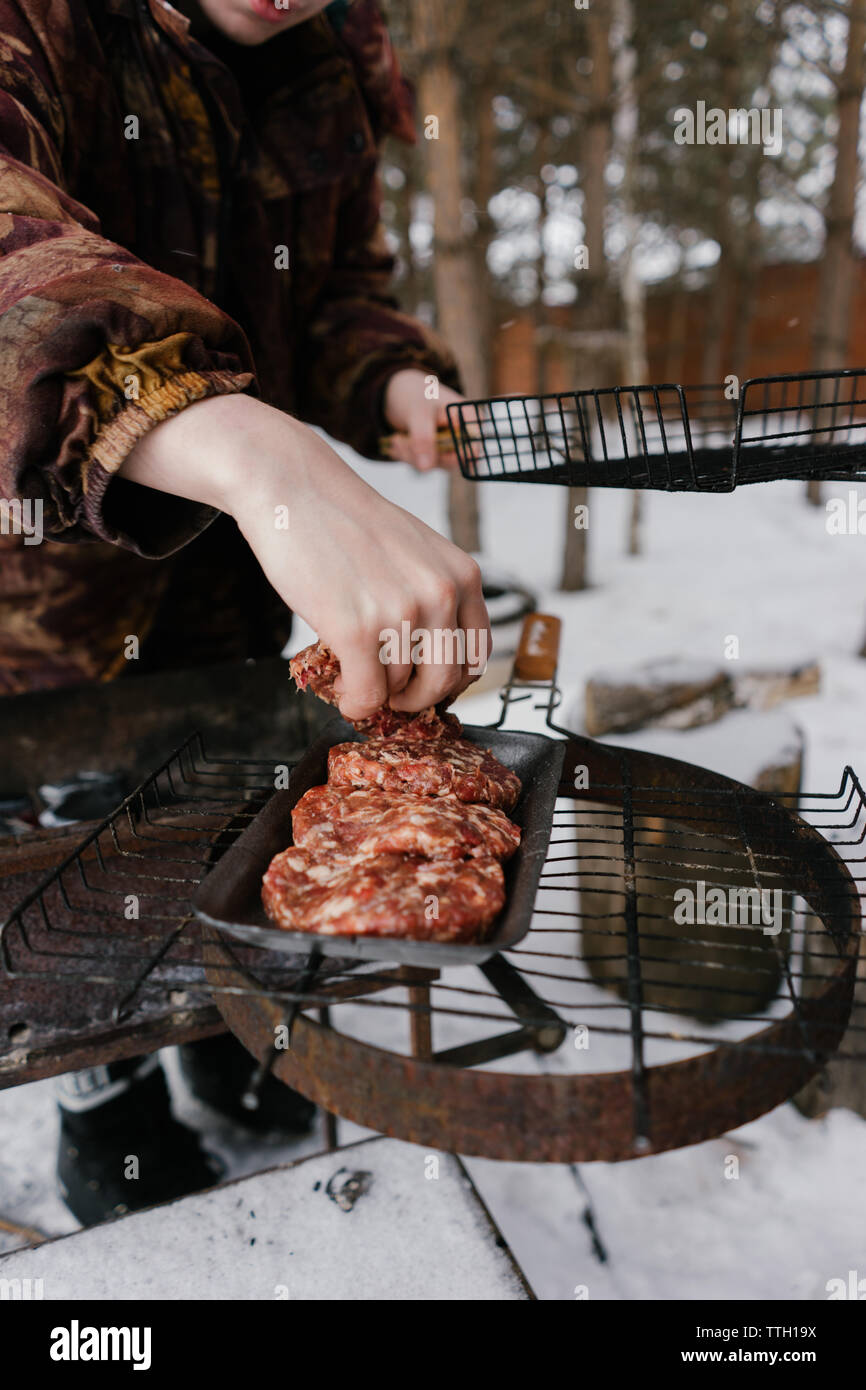 L'homme pour les hamburgers frites magrets. barbecue Banque D'Images