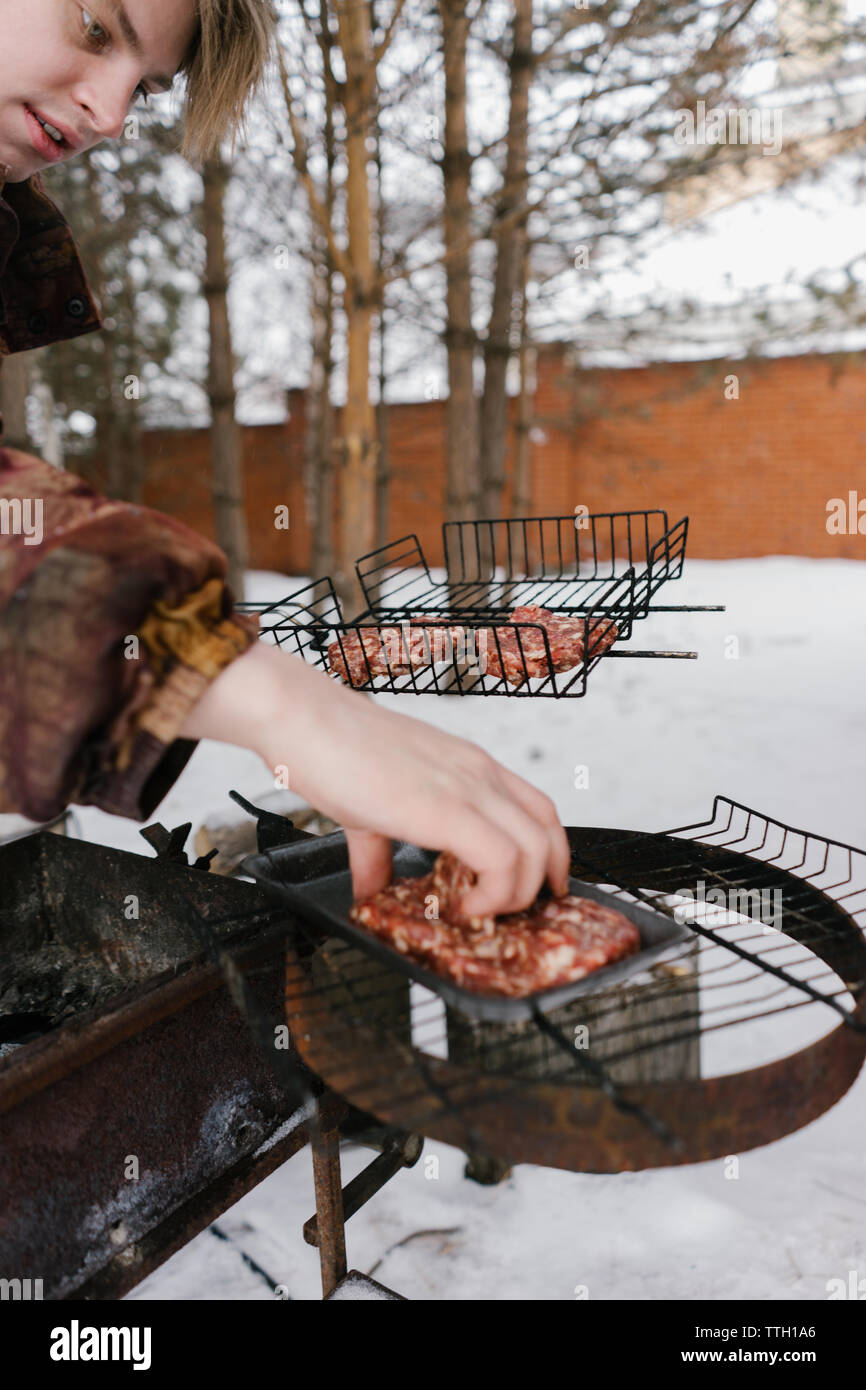 L'homme pour les hamburgers frites magrets. barbecue Banque D'Images