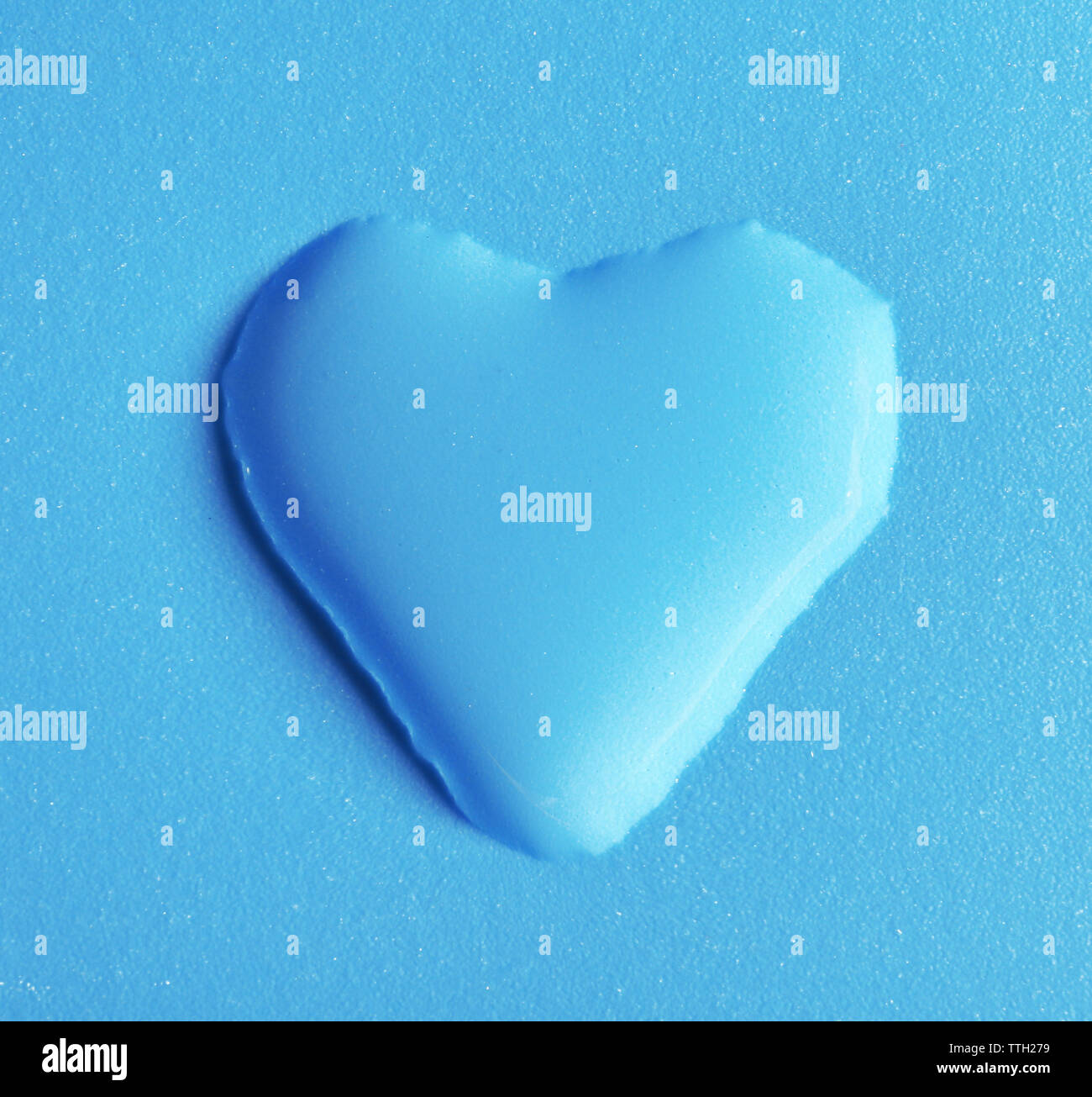 Coeur en goutte d'eau sur fond bleu Banque D'Images