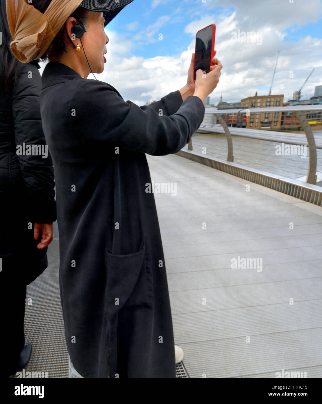 Londres, Angleterre, Royaume-Uni. Toursist japonais sur le pont du millénaire en prenant une photo avec son téléphone Banque D'Images