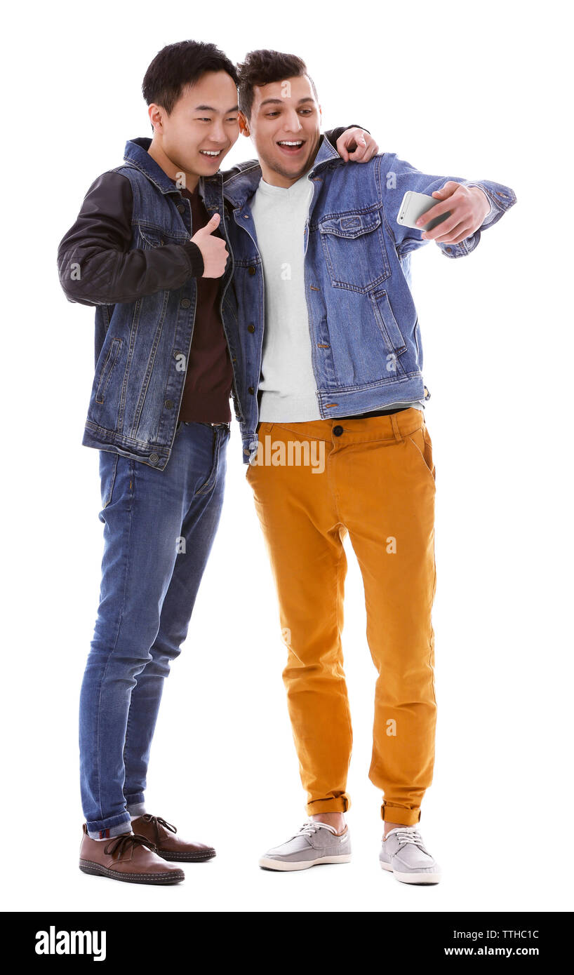 Deux jeunes hommes en tenant avec selfies mobile phone isolated on white Banque D'Images