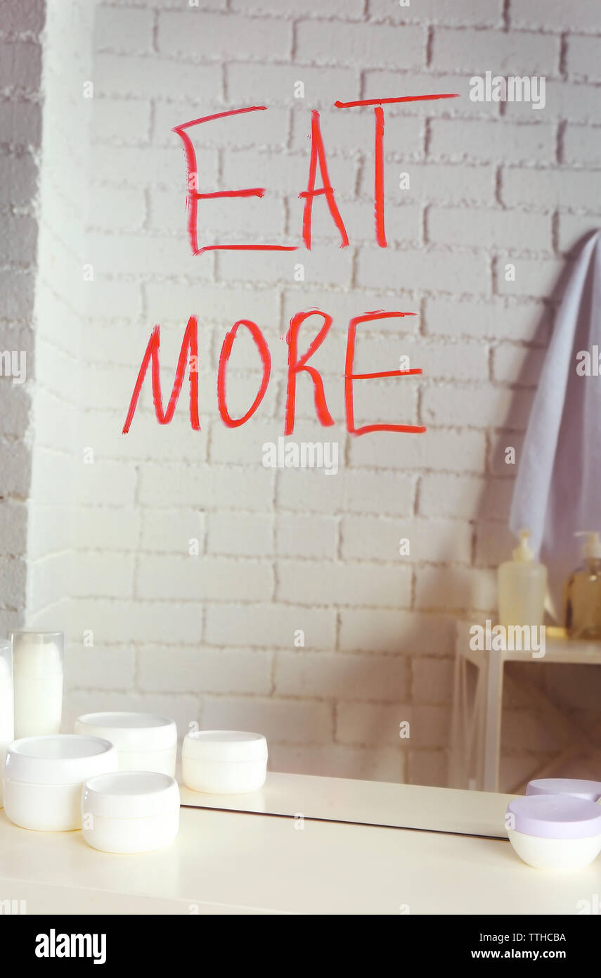 Manger plus de texte écrit sur un miroir dans la salle de bains Banque D'Images