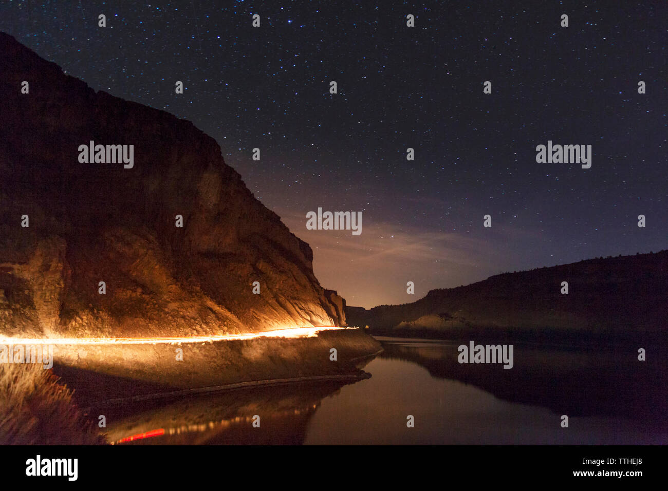 Vue panoramique sur le lac éclairé par mountain contre un ciel étoilé de nuit Banque D'Images