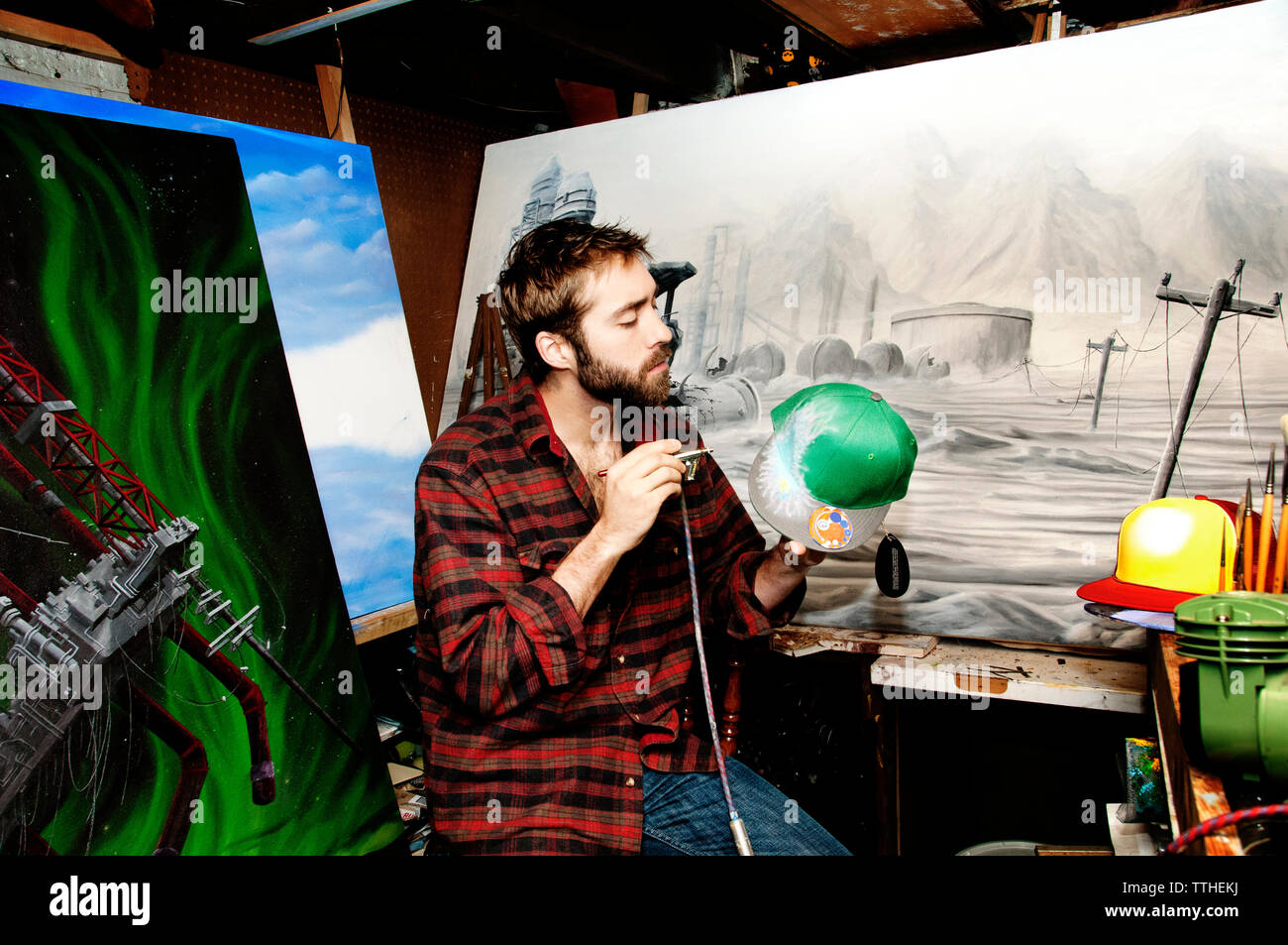 La peinture de l'artiste masculin à l'aérographe en studio Banque D'Images