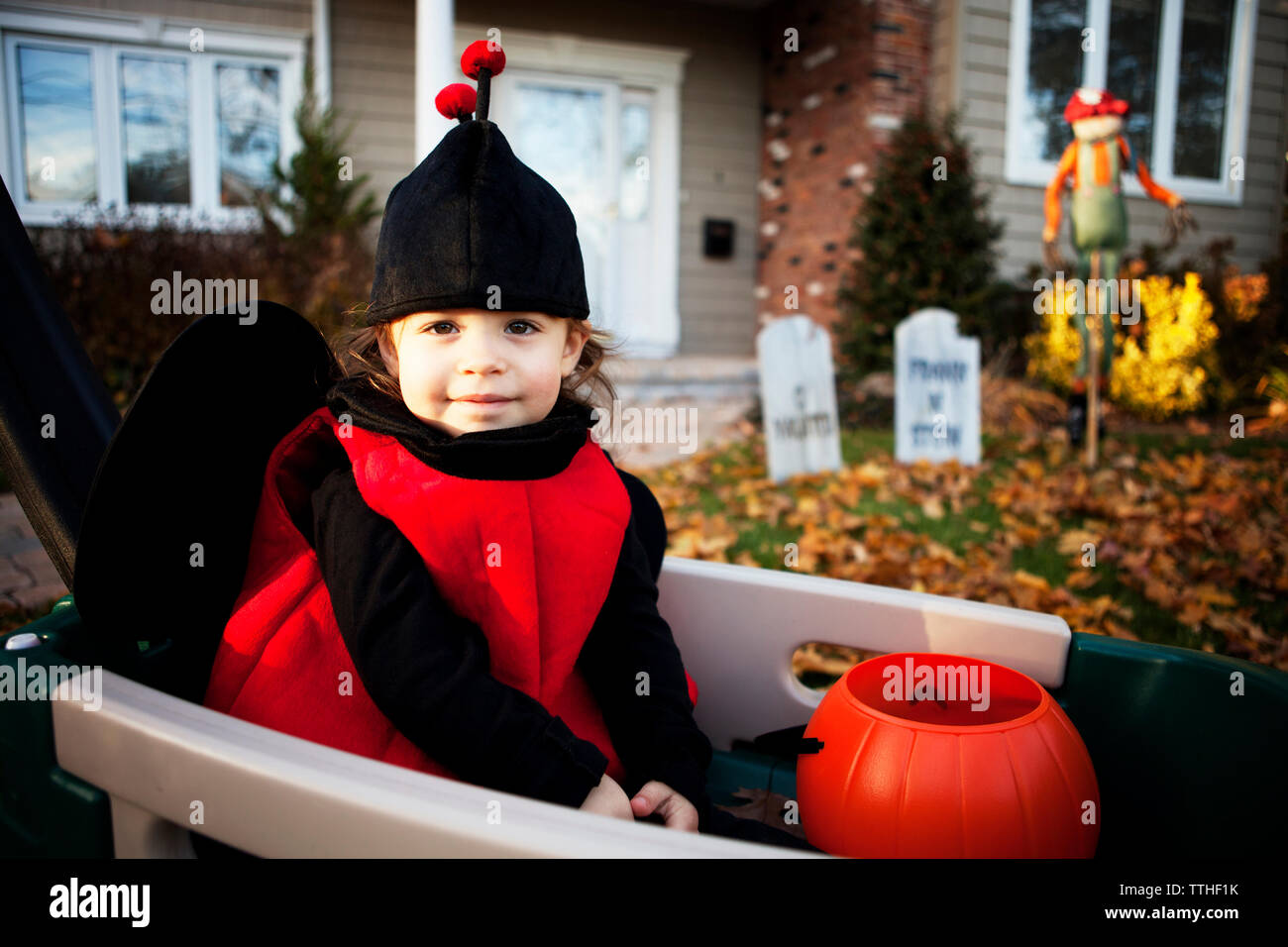 Portrait of happy girl wearing costume et assis dans le panier Banque D'Images