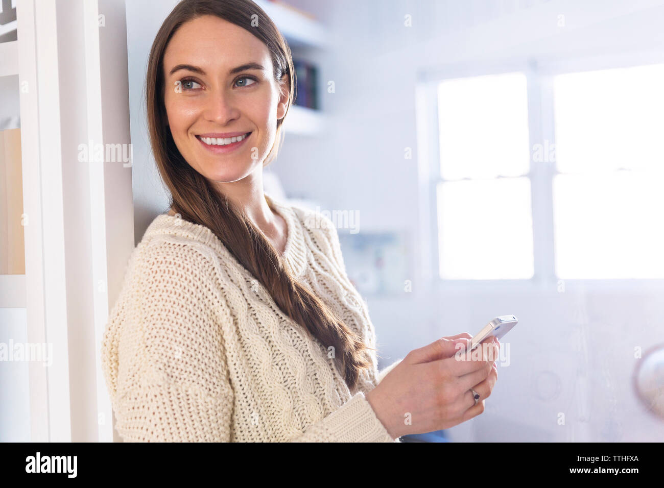 Happy woman en maintenant smart phone at home Banque D'Images