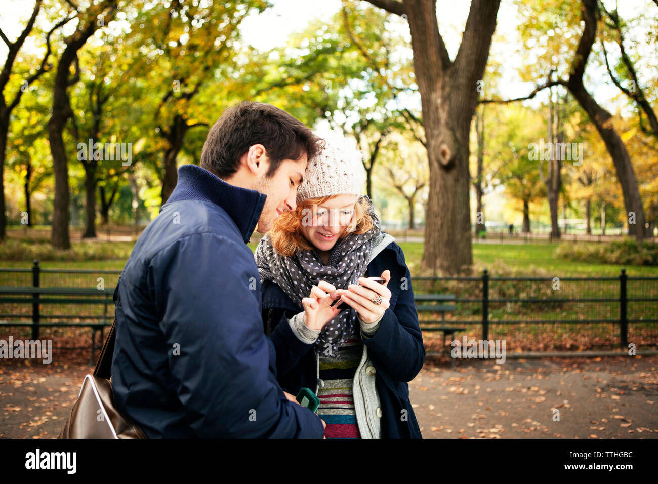 Jeune couple avec phone while standing in Central Park Banque D'Images