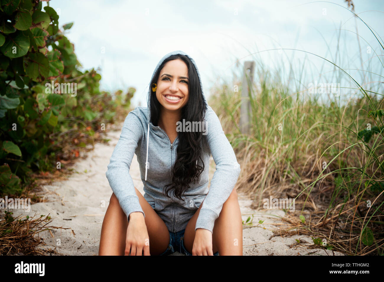 Portrait of happy woman sitting on beach Banque D'Images