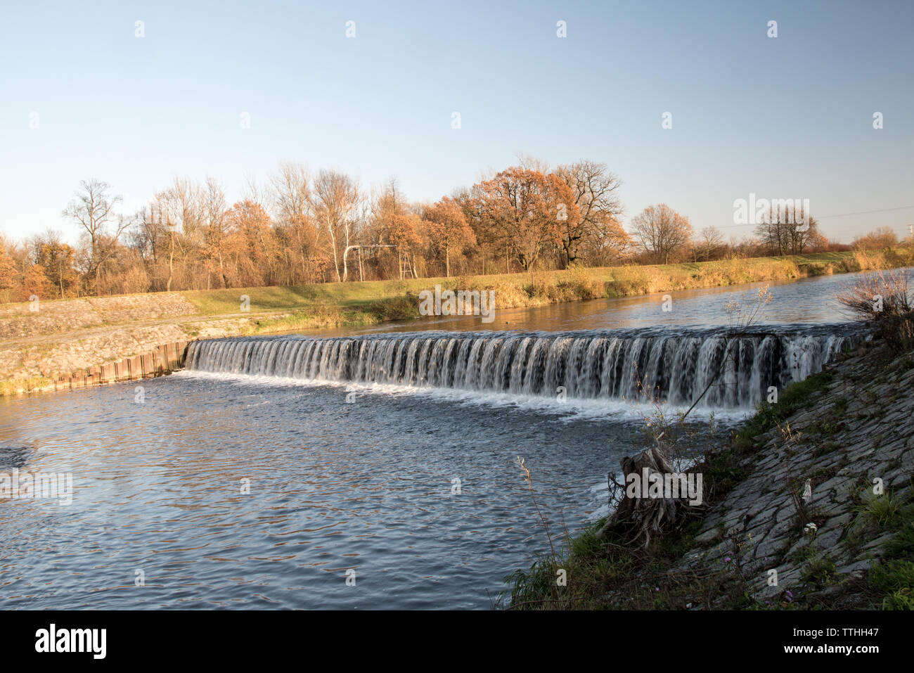 Weir sur la rivière Olse Karvina en ville en République tchèque avec des arbres sur l'arrière-plan au cours de l'automne journée avec un ciel clair Banque D'Images