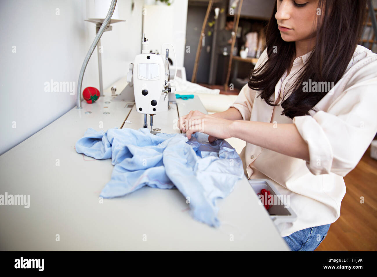 Designer de mode féminine concentrée sur tissu couture sewing machine Banque D'Images