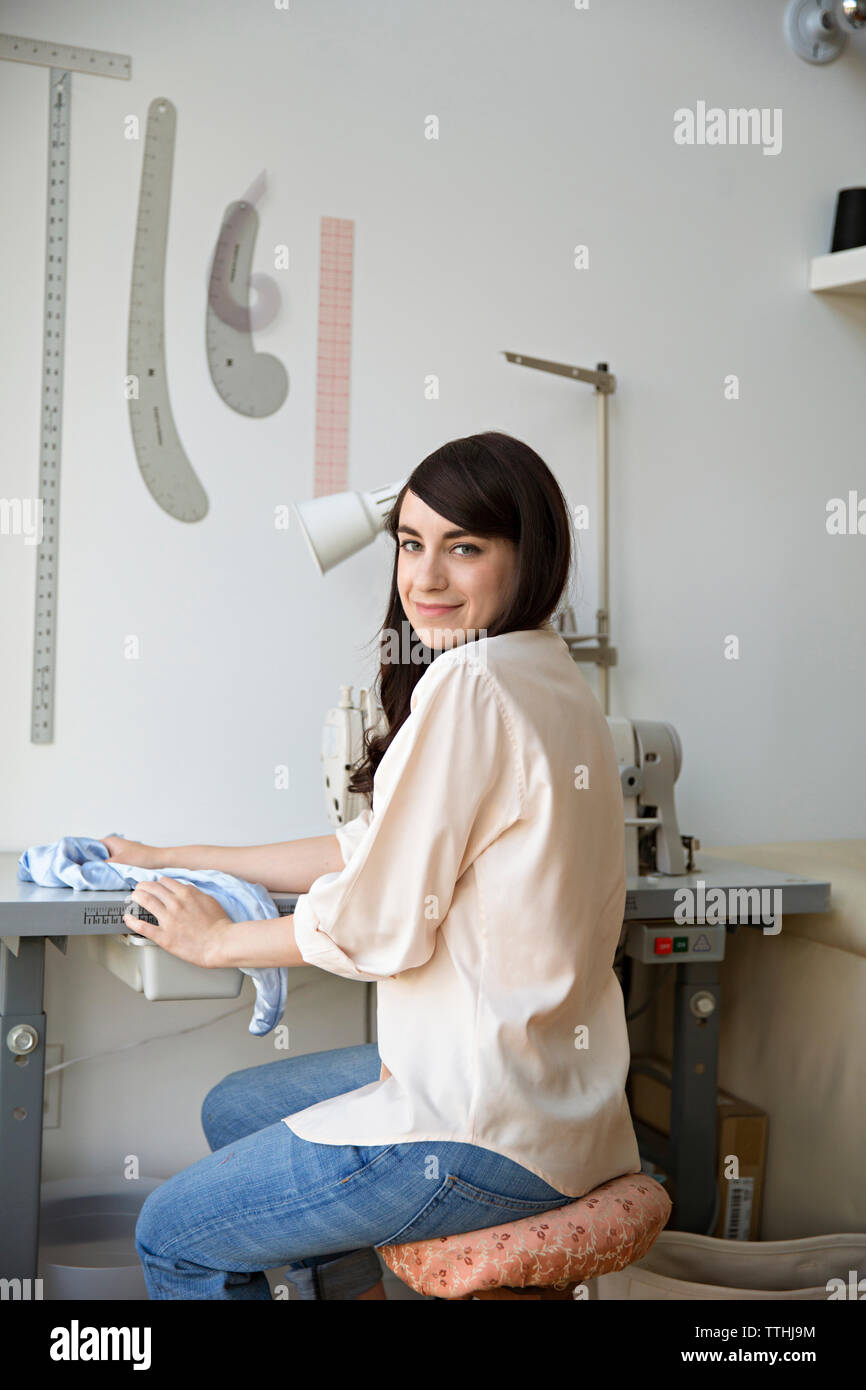 Portrait of happy female designer sitting in design studio Banque D'Images