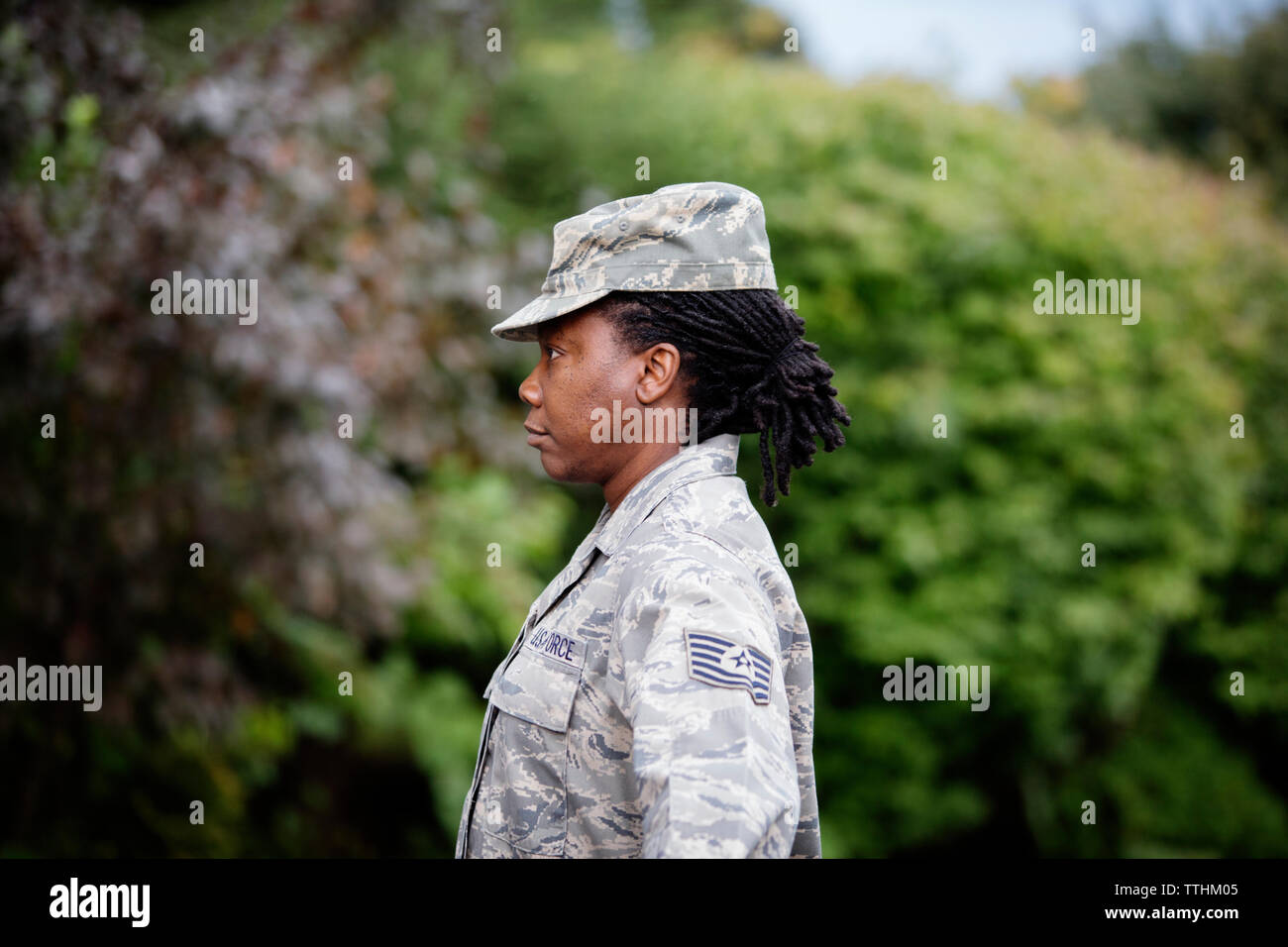Vue de profil de femme soldat debout contre des arbres Banque D'Images