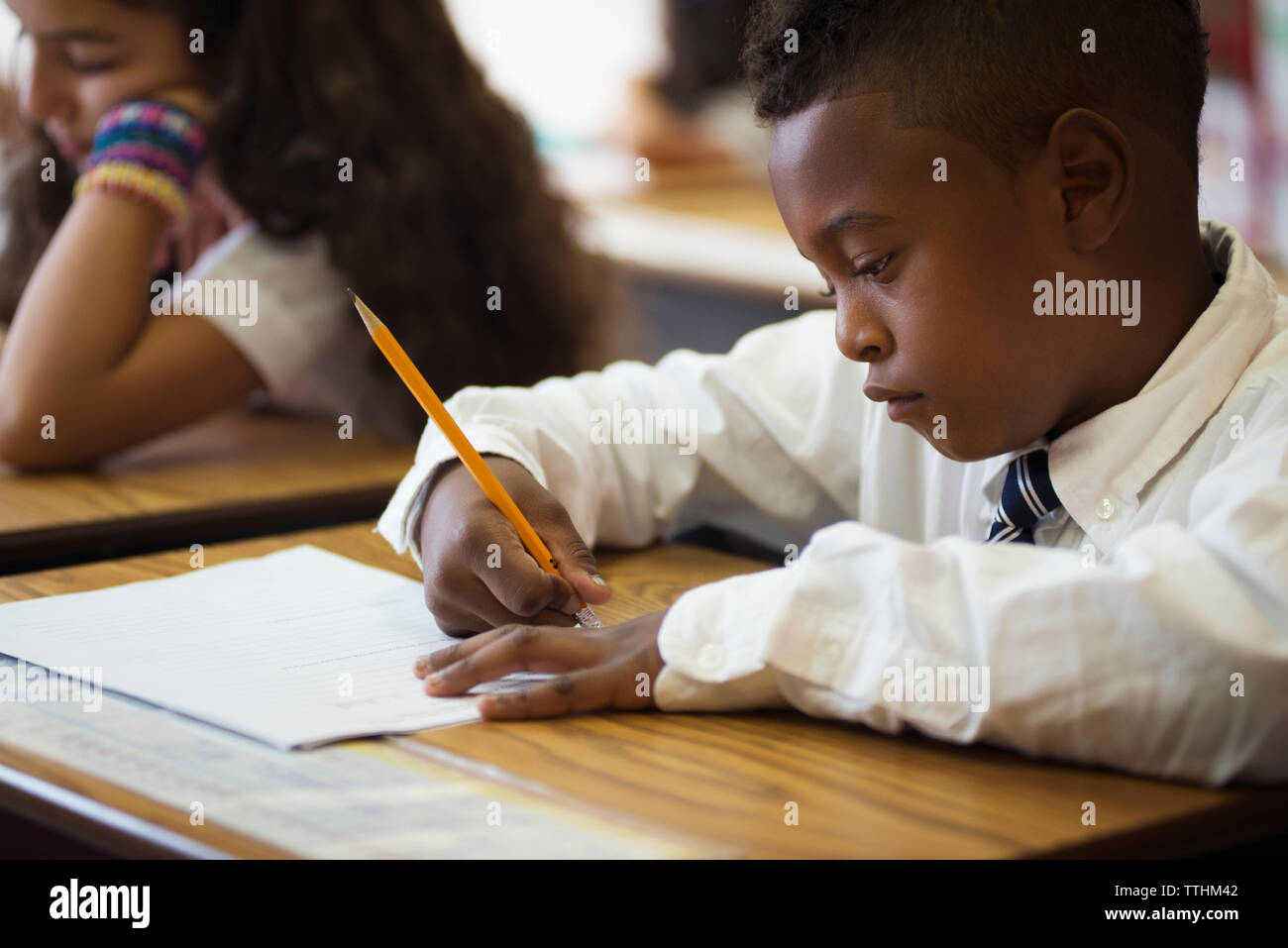 Garçon assis au bureau durant l'essai en classe Banque D'Images