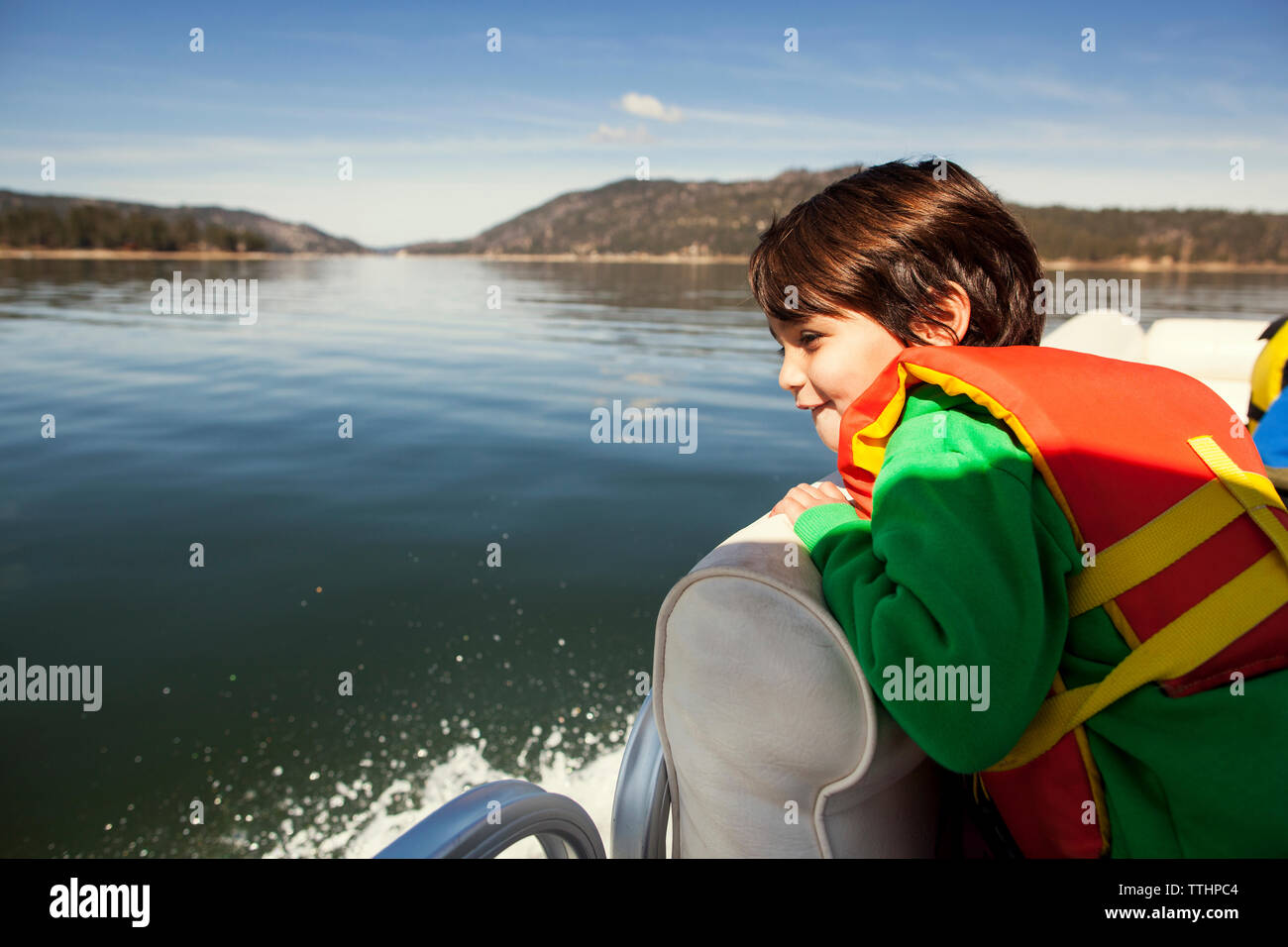 Boy looking at view while sitting on yacht Banque D'Images