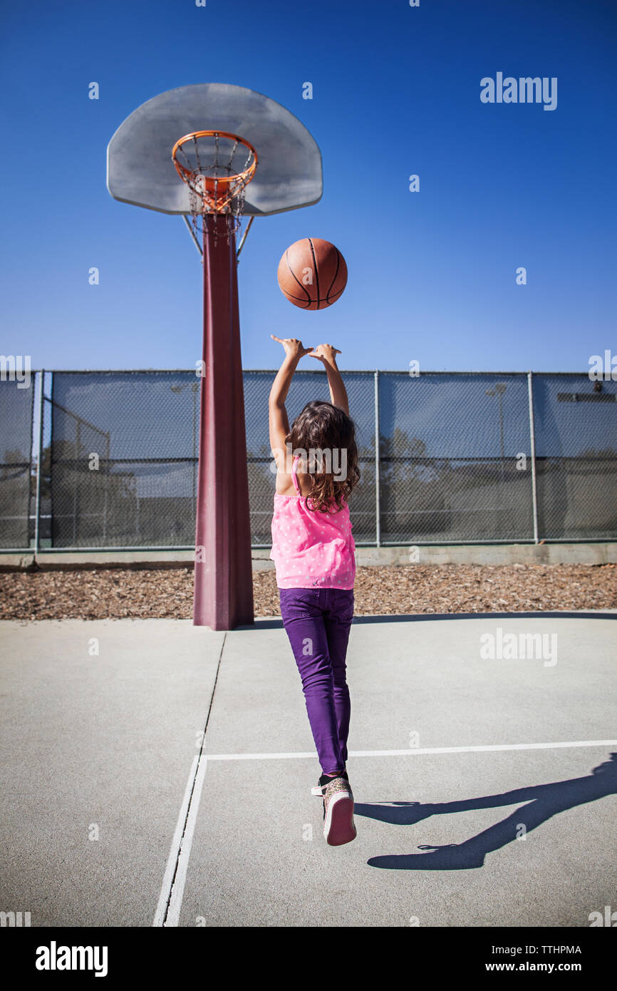 Girl playing basketball on court Banque D'Images