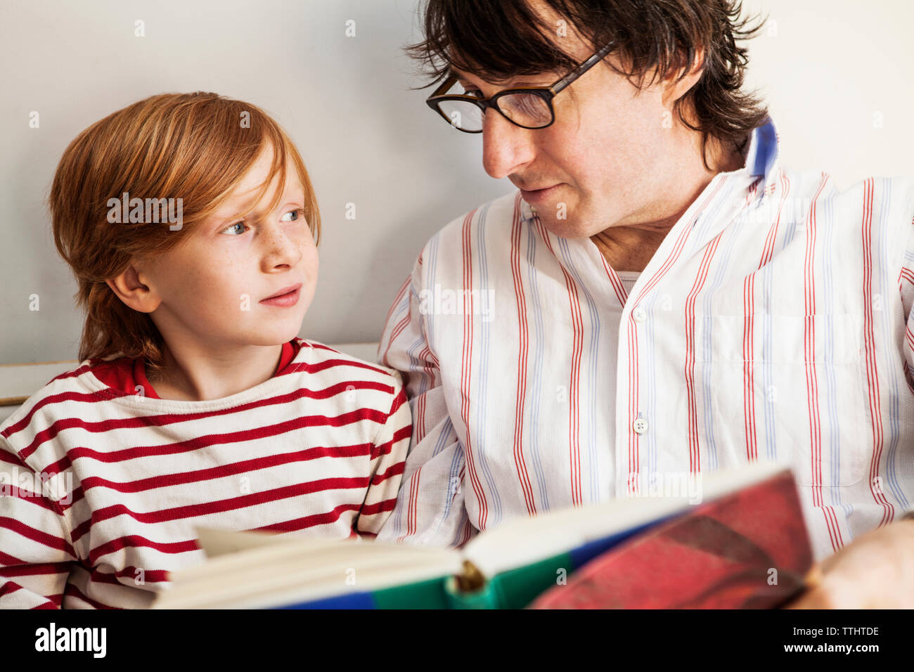 Père et fils la lecture de livre à la maison Banque D'Images
