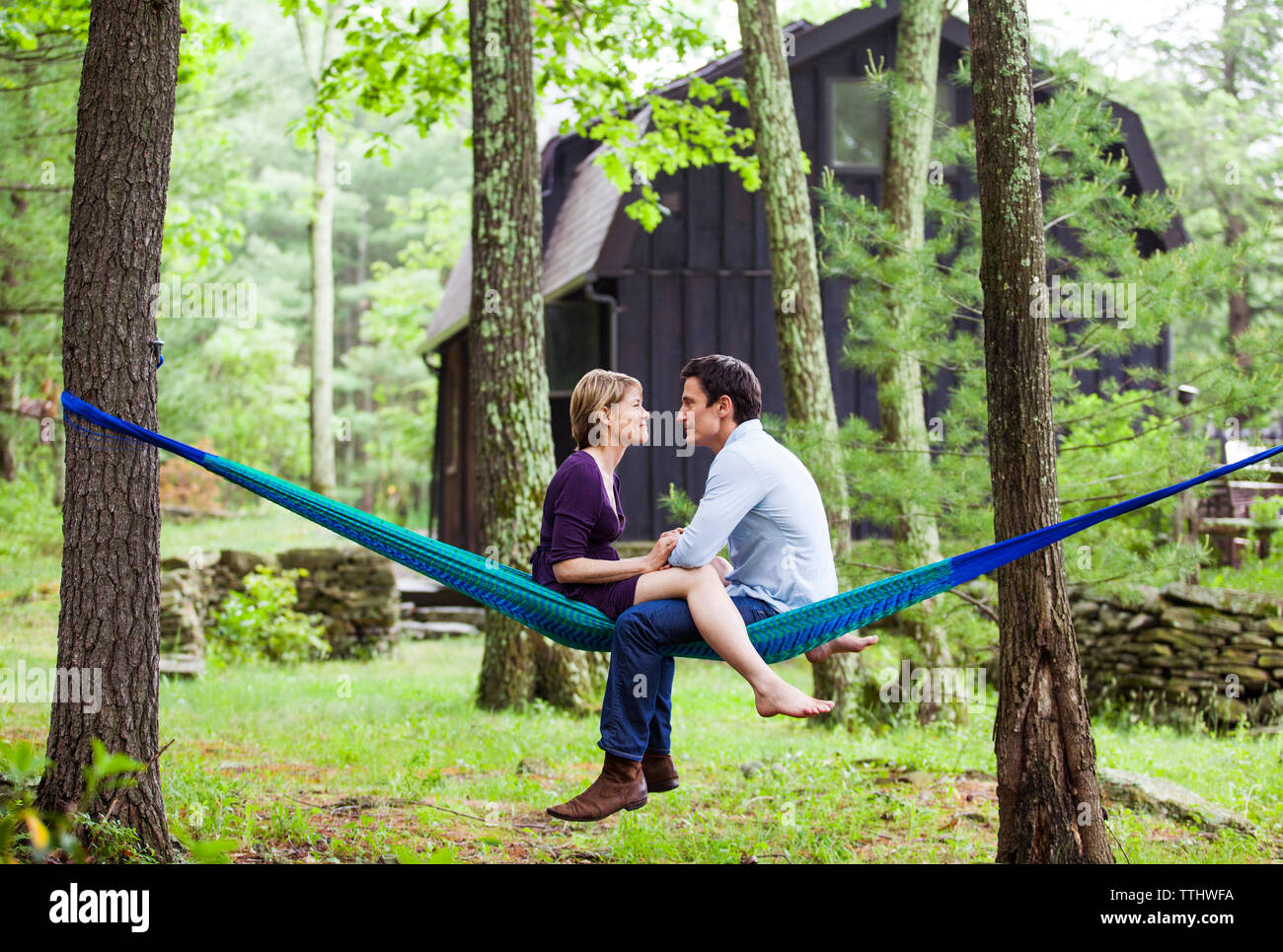 Couple talking while sitting on hammock Banque D'Images