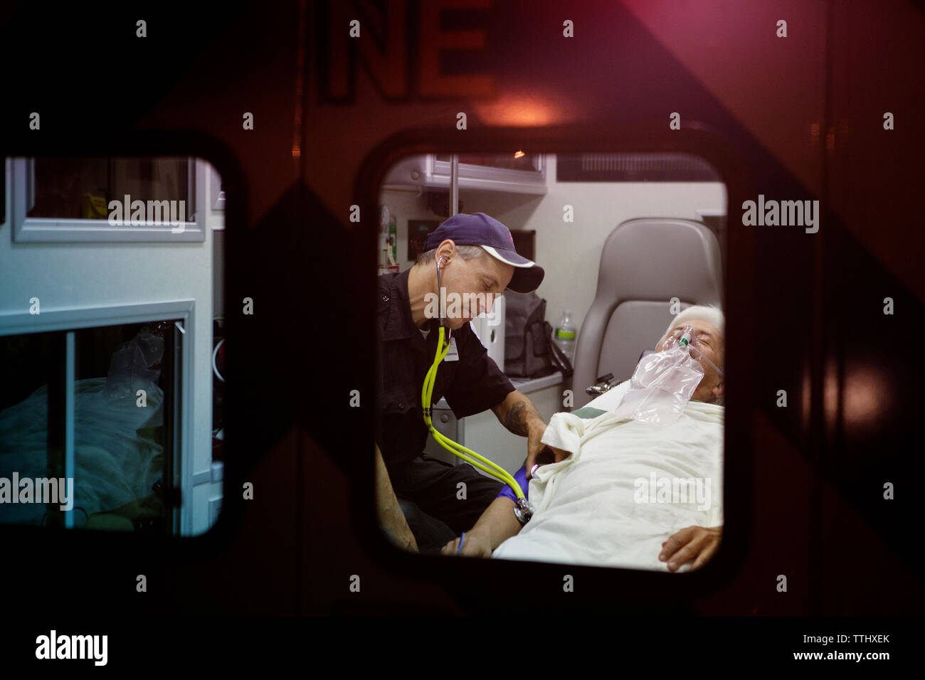 Sauveteur examining patient with stethoscope in ambulance Banque D'Images