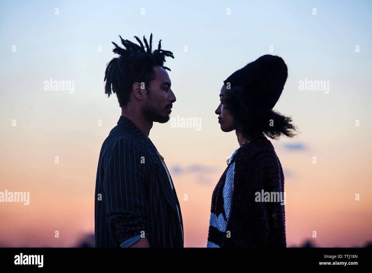 Couple debout face à face au crépuscule Banque D'Images