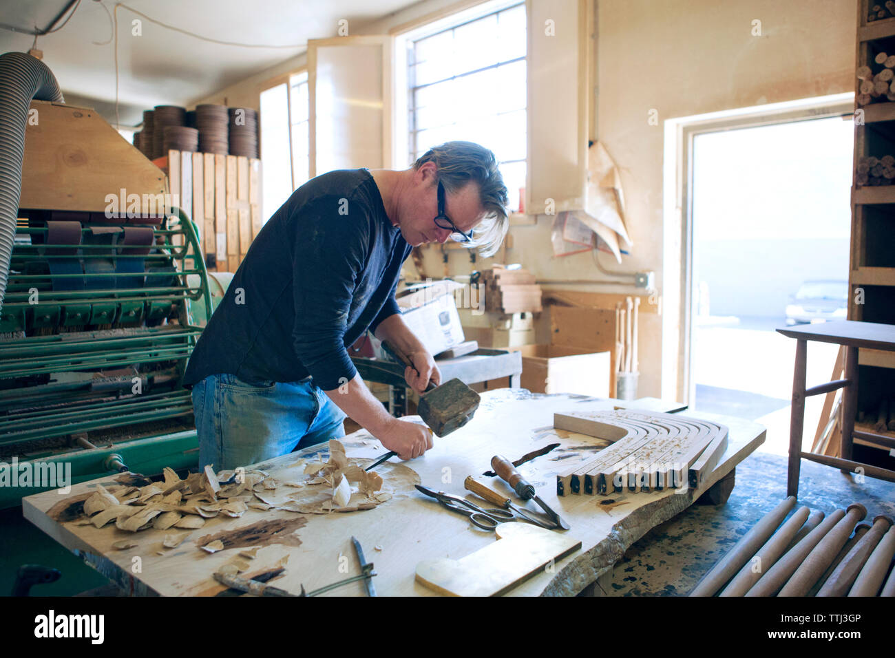 Male carpenter burinage bois en atelier Banque D'Images