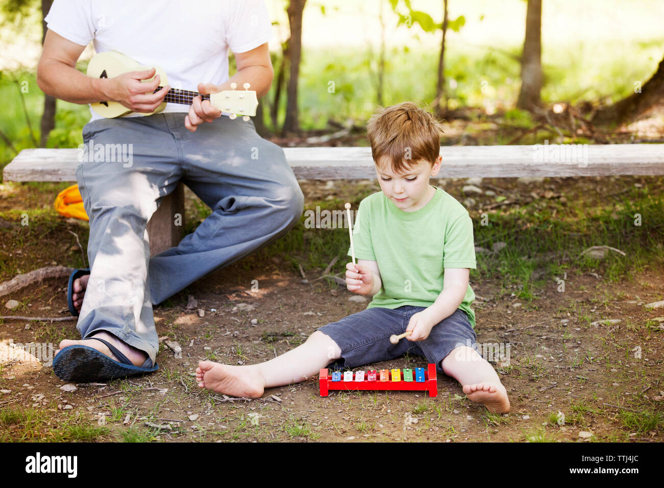 Père et fils jouant avec des instruments de musique à l'aire de jeux Banque D'Images
