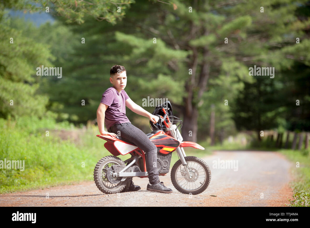 Portrait of boy sitting on dirt bike Banque D'Images