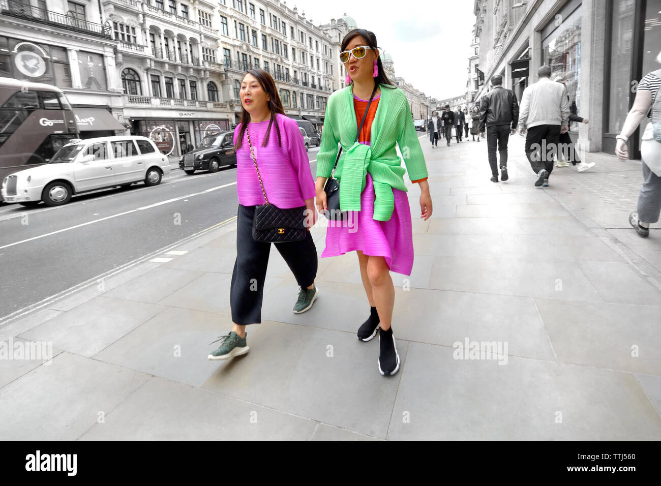 Londres, Angleterre, Royaume-Uni. Deux femmes asiatiques habillés de couleurs vives dans Regent Street (couleur sélective) Banque D'Images