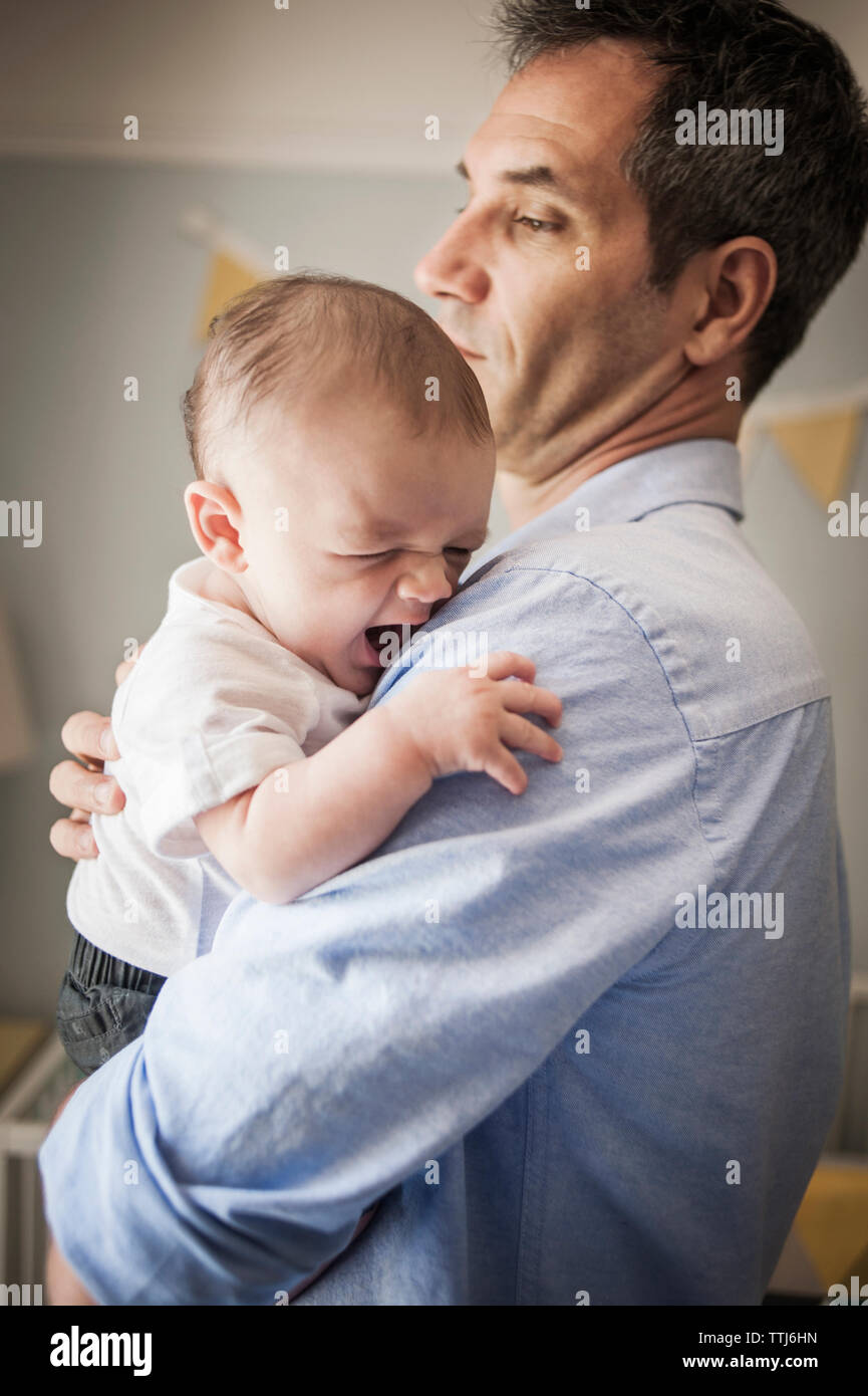 Man carrying baby boy alors qu'il se tenait à la maison Banque D'Images