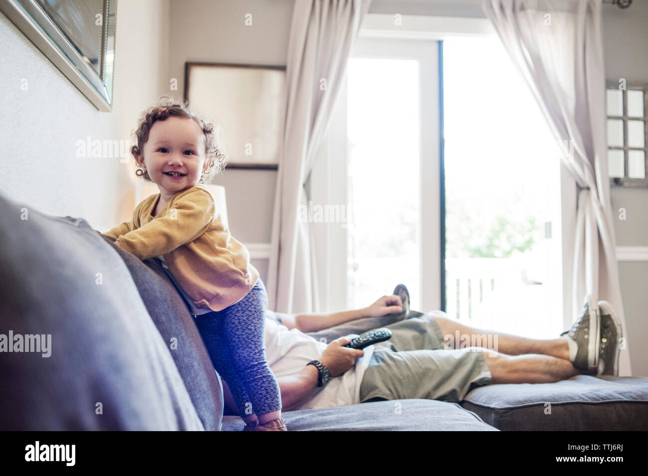 Happy baby girl avec le père sur canapé à la maison Banque D'Images